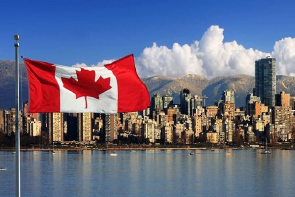 canadian-flag-flying-in-front-of-vancouver-skyline